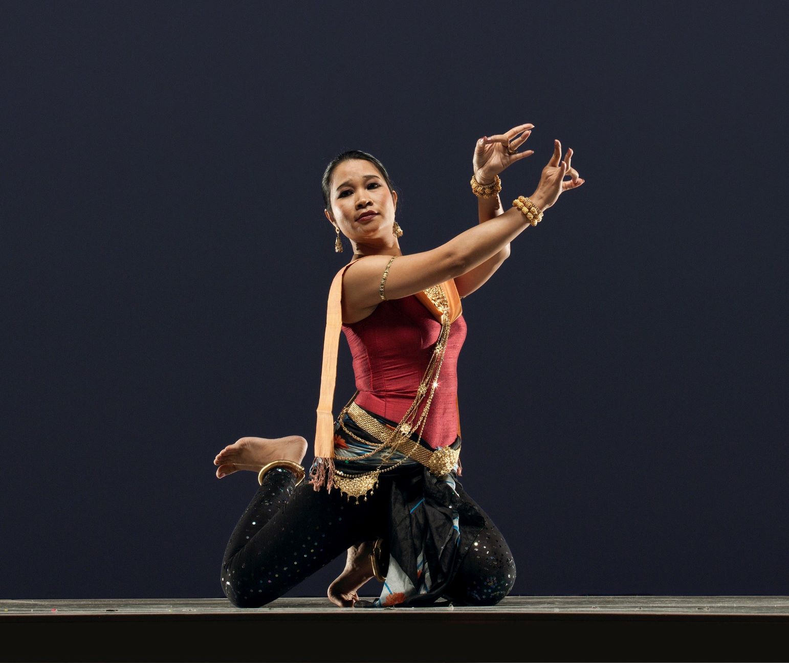 Woman in squatting position performing hand gestures